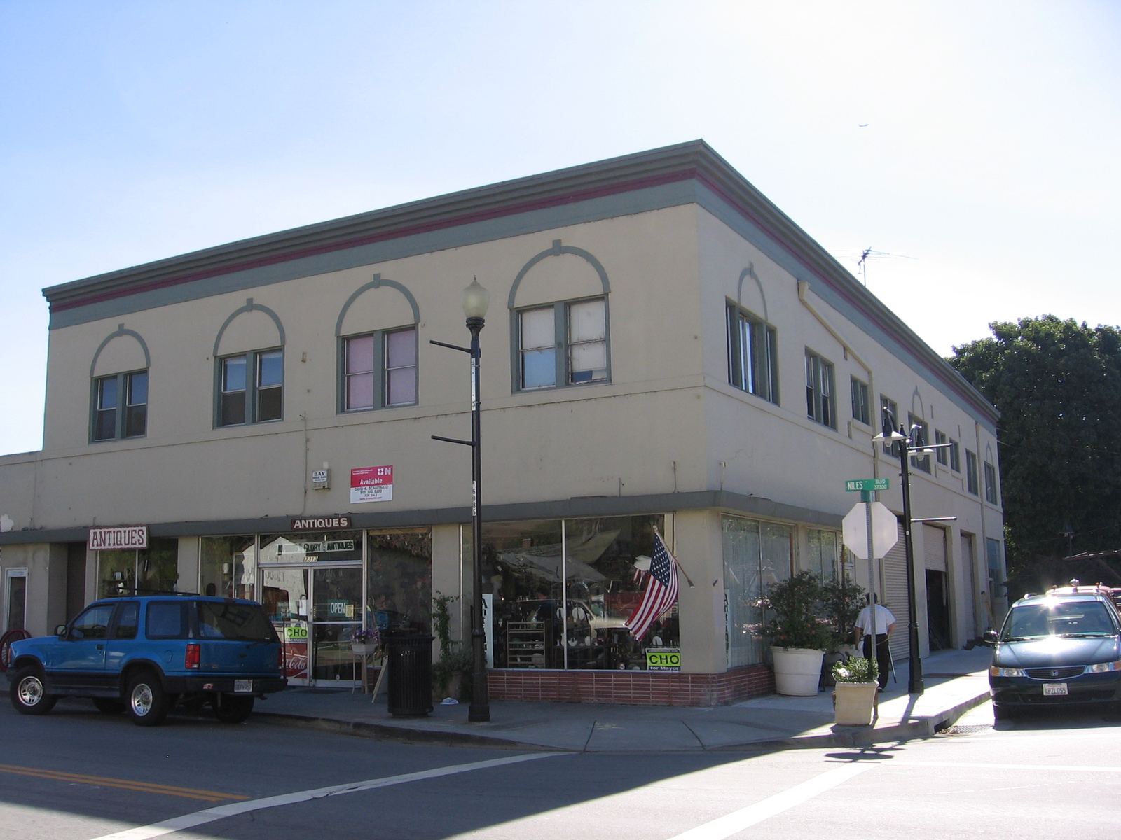 A two-story beige commercial building with storefronts on a sunny Fremont street corner, Niles Boulevard.